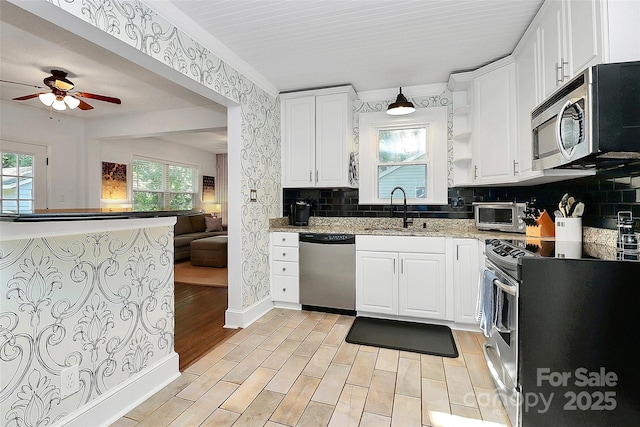 kitchen featuring backsplash, stainless steel appliances, white cabinetry, and sink