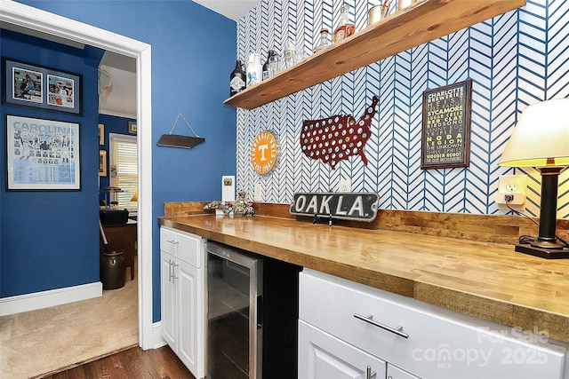 kitchen featuring butcher block countertops, dark hardwood / wood-style floors, white cabinets, and wine cooler