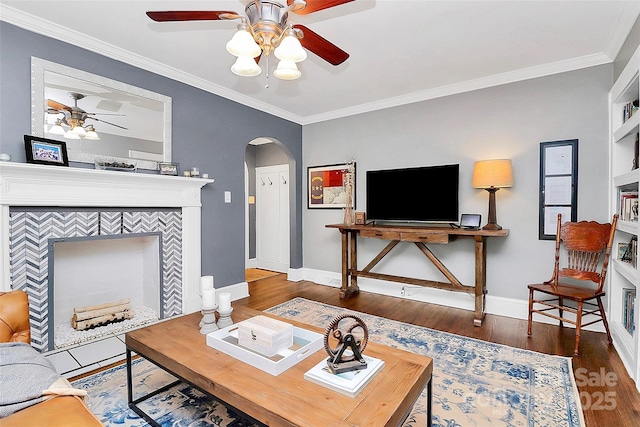 living room with built in shelves, dark hardwood / wood-style flooring, and crown molding