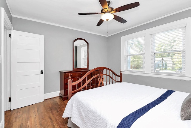 bedroom with dark hardwood / wood-style flooring, ceiling fan, and crown molding