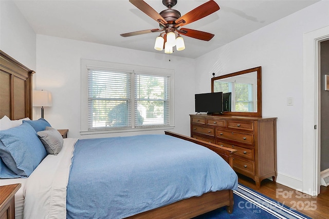 bedroom with dark hardwood / wood-style flooring and ceiling fan