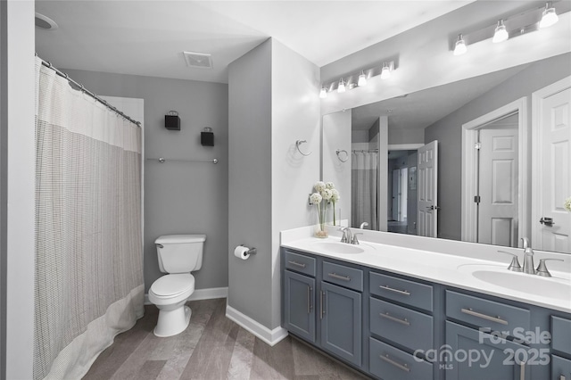 bathroom featuring toilet, vanity, and a shower with curtain