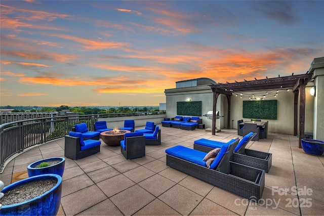 patio terrace at dusk featuring an outdoor living space with a fire pit and a pergola