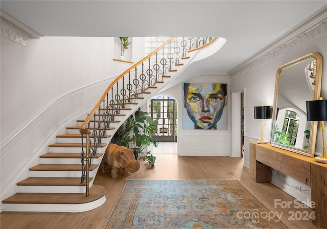 entryway with crown molding and hardwood / wood-style floors