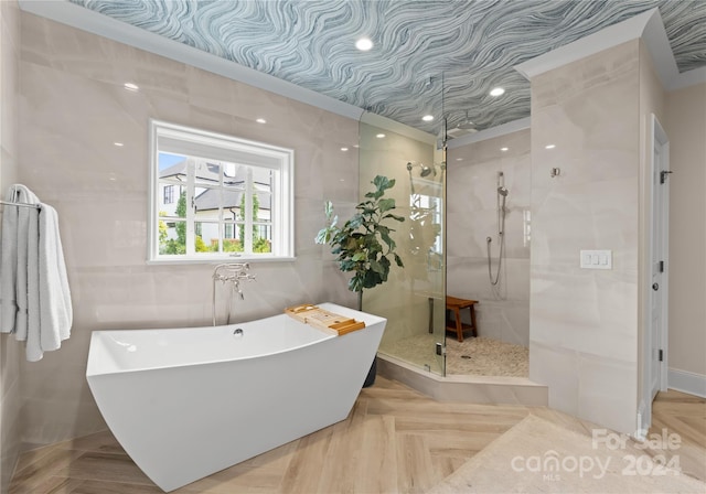 bathroom featuring parquet floors, shower with separate bathtub, and tile walls