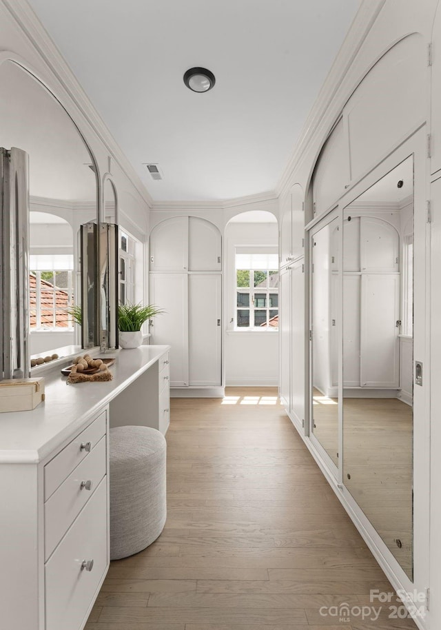 interior space with ornamental molding and light hardwood / wood-style flooring