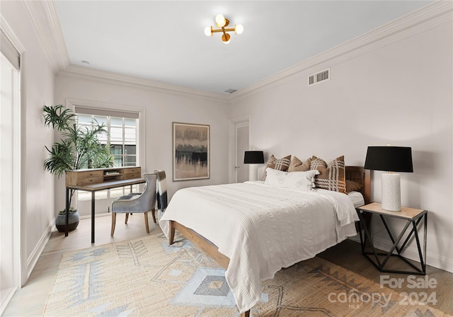 bedroom with crown molding, hardwood / wood-style flooring, and an inviting chandelier