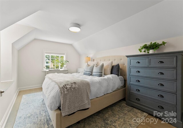 bedroom featuring dark wood-type flooring and vaulted ceiling