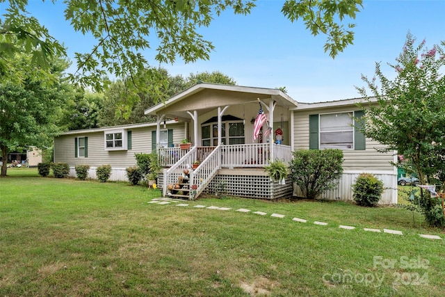 manufactured / mobile home with a front lawn and a porch