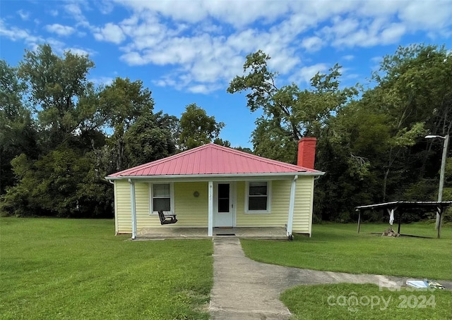 view of front of property featuring covered porch and a front yard