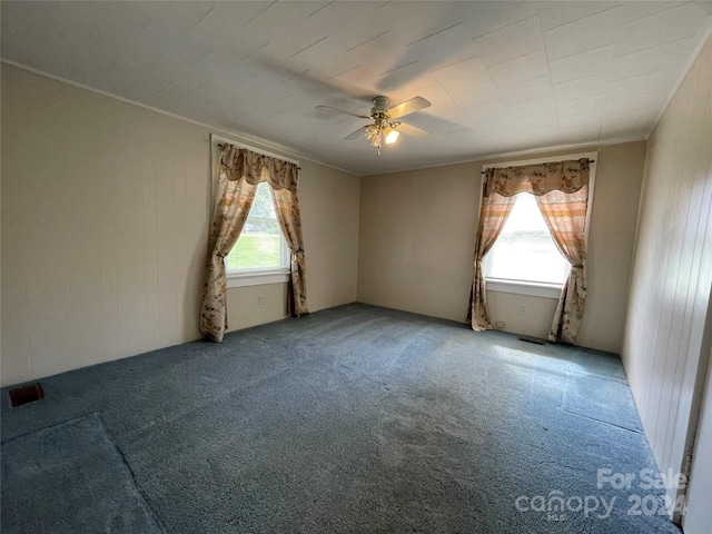 empty room featuring ceiling fan, ornamental molding, and carpet flooring