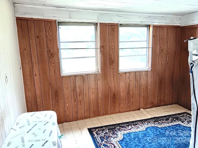 bedroom featuring multiple windows and wooden walls