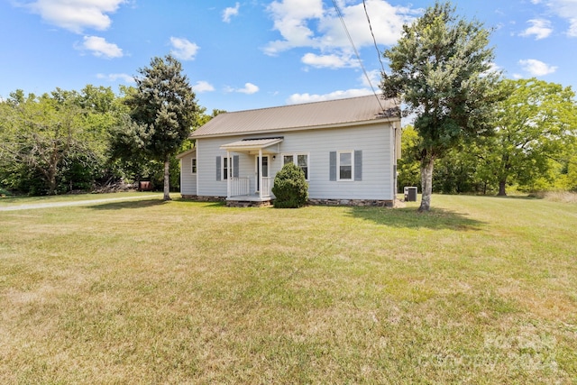 back of house featuring a lawn and central AC unit