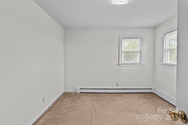 spare room with light carpet and baseboard heating