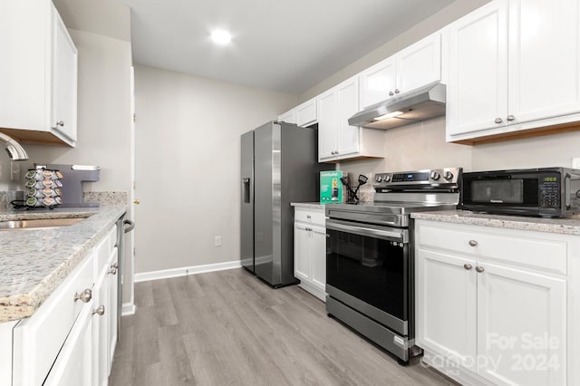 kitchen featuring light wood-type flooring, white cabinetry, stainless steel appliances, light stone counters, and sink