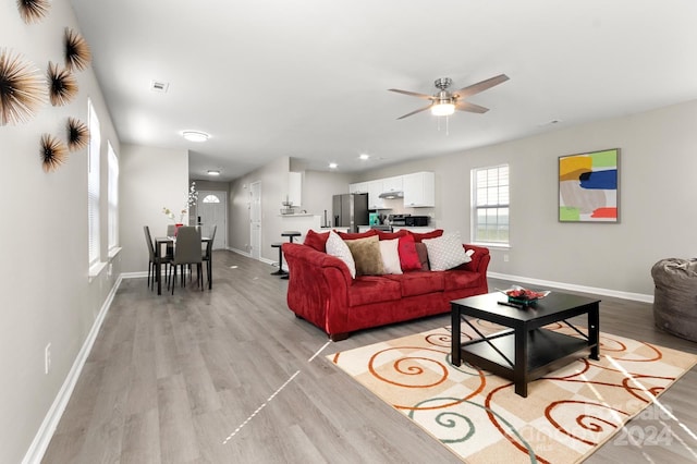 living room featuring light wood-type flooring and ceiling fan