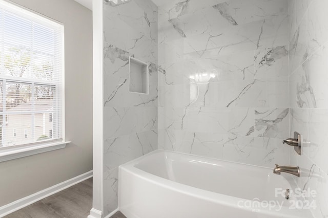 bathroom featuring tiled shower / bath and wood-type flooring