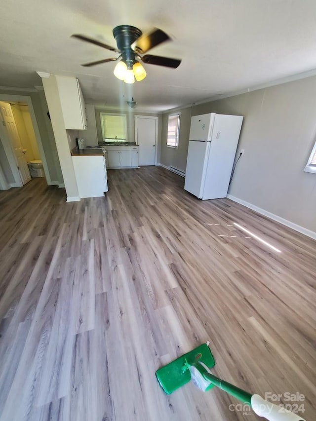 unfurnished living room with crown molding, light hardwood / wood-style flooring, a baseboard radiator, and ceiling fan