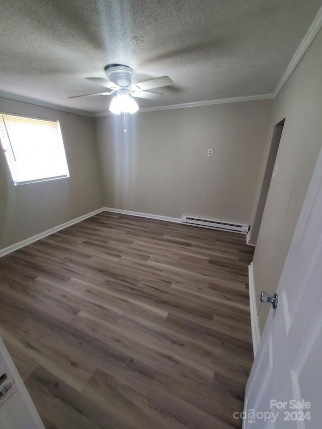 empty room with a textured ceiling, dark hardwood / wood-style flooring, ceiling fan, ornamental molding, and baseboard heating