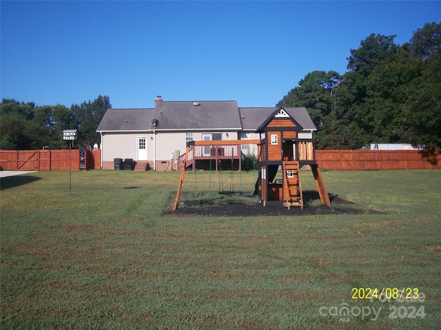 exterior space featuring a playground, a deck, and a lawn