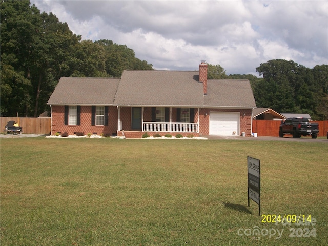 single story home featuring a porch, a garage, and a front lawn