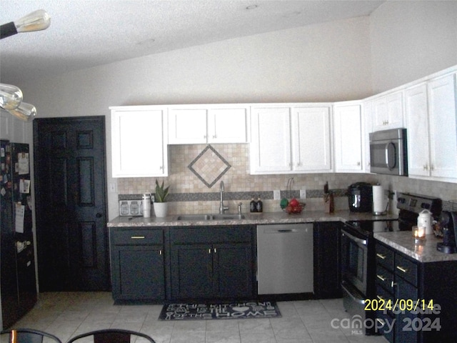 kitchen with white cabinets, appliances with stainless steel finishes, vaulted ceiling, and sink