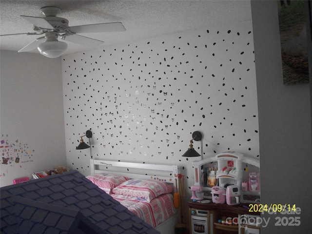 bedroom featuring ceiling fan and a textured ceiling