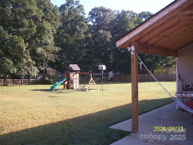 view of yard featuring a playground and a patio area