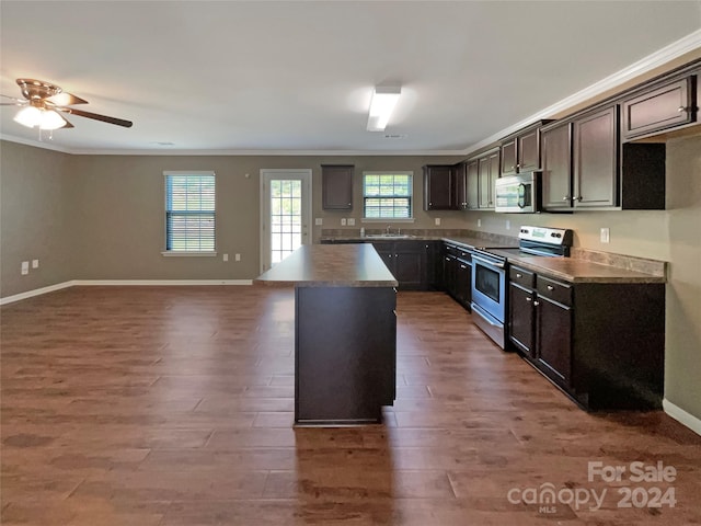 kitchen featuring appliances with stainless steel finishes, wood finished floors, a sink, and ornamental molding