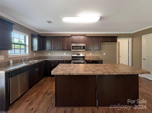 kitchen with visible vents, dark wood finished floors, appliances with stainless steel finishes, crown molding, and a sink