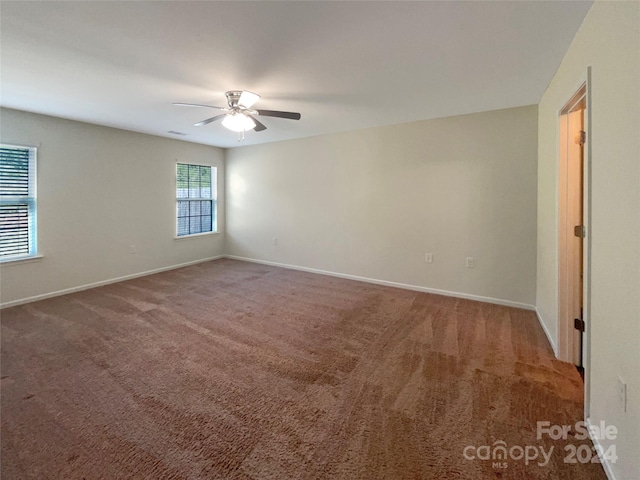 carpeted empty room with baseboards and a ceiling fan