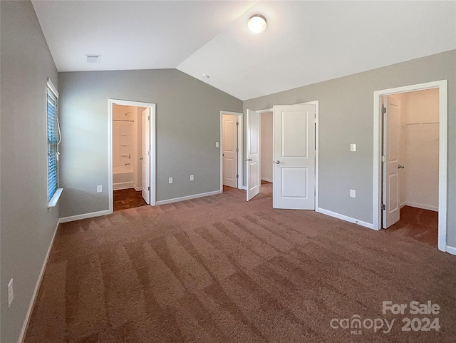 unfurnished bedroom featuring lofted ceiling, baseboards, a spacious closet, and visible vents