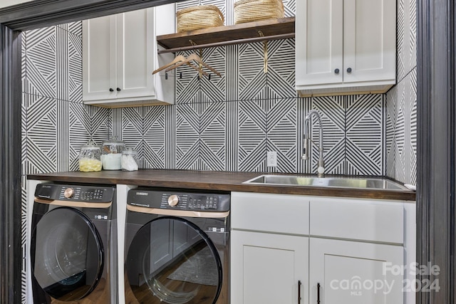 laundry room featuring cabinets, independent washer and dryer, and sink