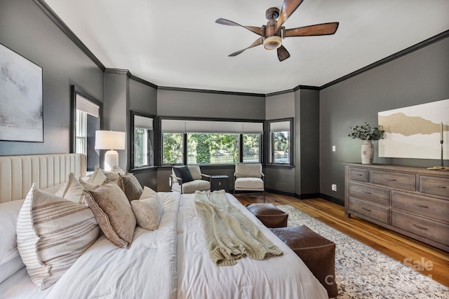 bedroom featuring ceiling fan, light wood-type flooring, crown molding, and radiator heating unit