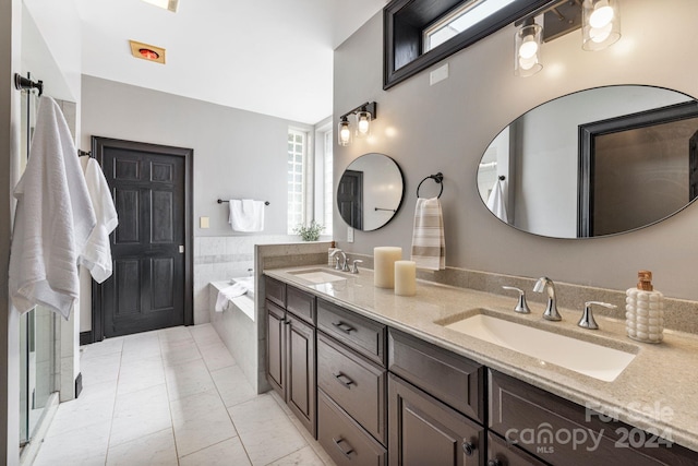 bathroom with vanity, a wealth of natural light, and a relaxing tiled tub