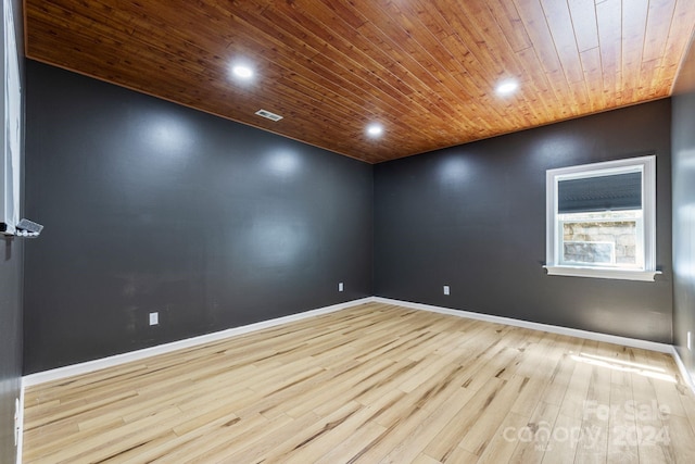 empty room featuring light hardwood / wood-style floors and wooden ceiling