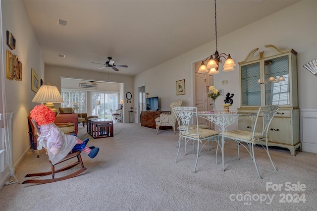 dining space with ceiling fan with notable chandelier and carpet floors