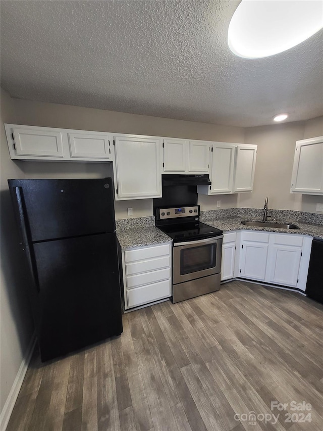 kitchen with a sink, freestanding refrigerator, white cabinets, stainless steel electric range oven, and dark wood-style flooring