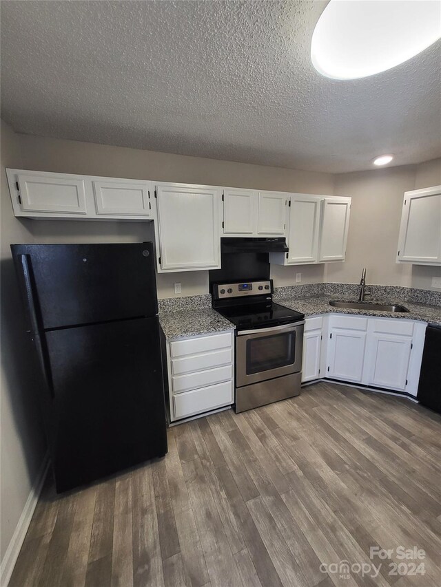 5720 Ebley Ln, Charlotte, NC 28227 - kitchen with stainless steel electric range oven, freestanding refrigerator, white cabinetry, dark wood-style floors, and light stone counters