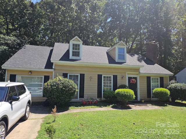 cape cod house with a garage and a front lawn