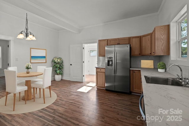 kitchen featuring sink, dark hardwood / wood-style flooring, stainless steel refrigerator with ice dispenser, backsplash, and decorative light fixtures