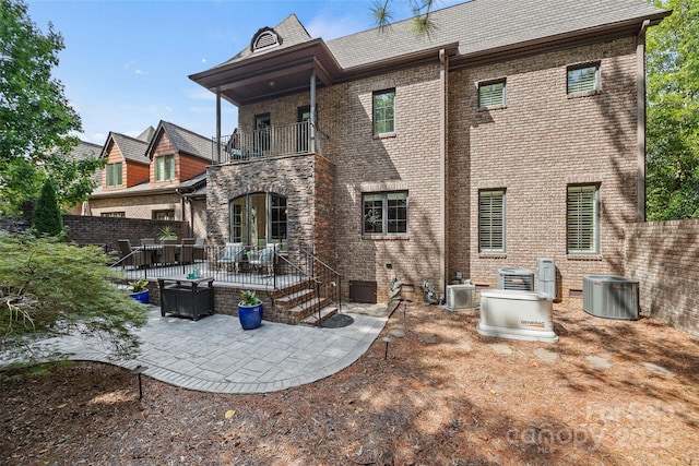 back of house with central AC, a balcony, and a patio area