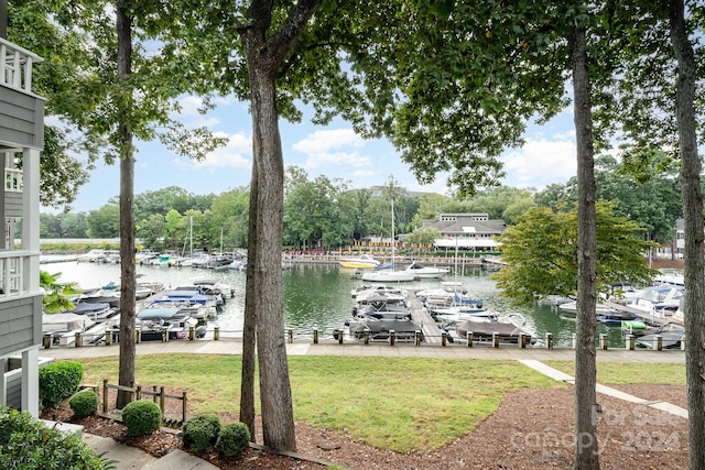 dock area with a lawn and a water view