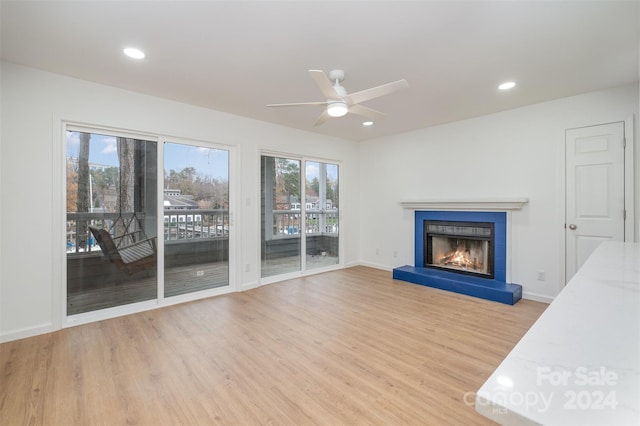 unfurnished living room with ceiling fan and light hardwood / wood-style floors