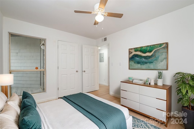 bedroom with electric panel, ceiling fan, and light hardwood / wood-style floors