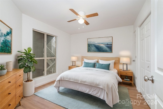 bedroom with light wood-type flooring, a closet, and ceiling fan