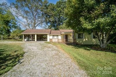 view of front of property with a carport and a front lawn