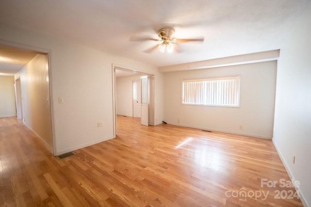 unfurnished room with light wood-type flooring and ceiling fan