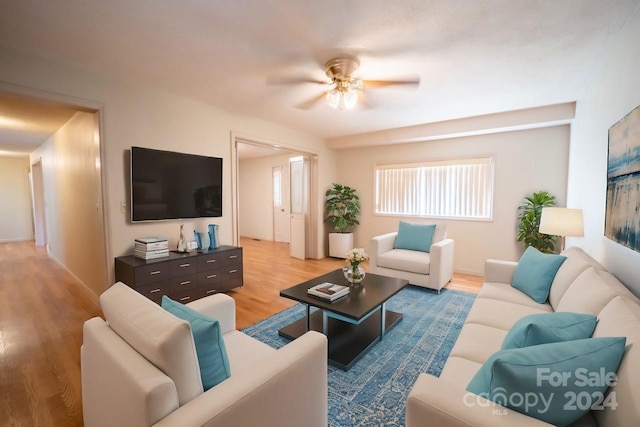 living room featuring ceiling fan and light hardwood / wood-style floors