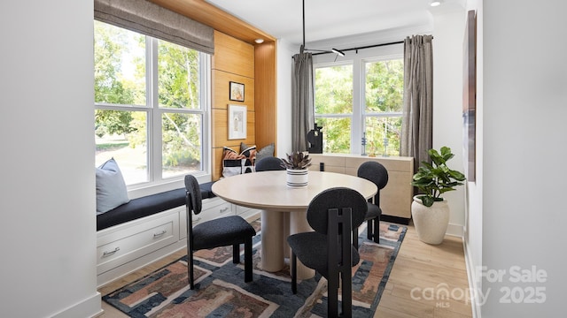 dining space with baseboards and wood finished floors